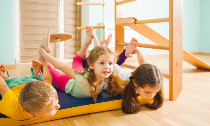 Kinder die beim Kinderturnen zusammen spielen.